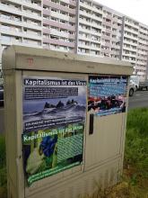 Antikapitalistische Plakate an einem Stromkasten vor einem Wohnblock in Magdeburg Nord