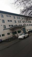 Bild der psychiatrischen Forensik neben der JVA in Essen, mit einem weisen Auto davor.