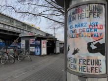 Plakat mit Slogans "Kein Freund - Kein Helfer" und "15. Märt ist Tag gegen Polizeigewalt" in einer Werbevitrine am Kottbusser Tor