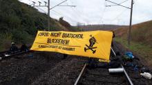 Transparent über die Schienen gespannt: "COP26: Nicht quatschen - blockieren"