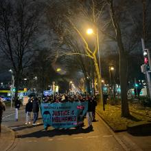 Die Spontandemonstration nach dem Freispruch für die Mörder von Mouhamed läuft über die Mallinckrodtstraße. Die erste Reihe trägt ein Transparent mit der Aufschrift "Justice for Mouhamed"