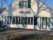 Seitenfassade des Restaurants "Alter Krug" in Berlin-Dahlem mit großem Schriftzug "FRONTEX KILLS" 