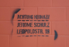 Schwarzes Stencil an roter Wand. darauf steht: "Achtung Neonazi! Jerome Schulz, Leopoldstraße 19"